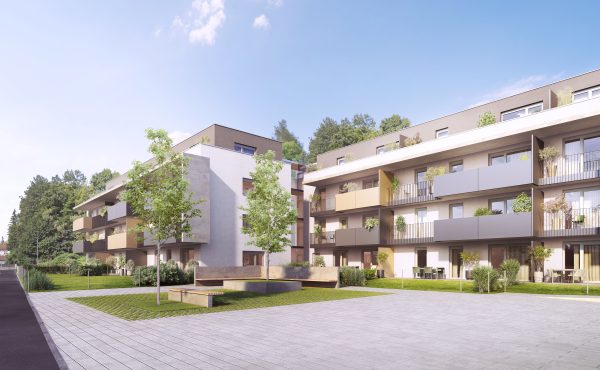 Moderne Wohnanlage mit Balkonen und Grünflächen an einem sonnigen Tag.