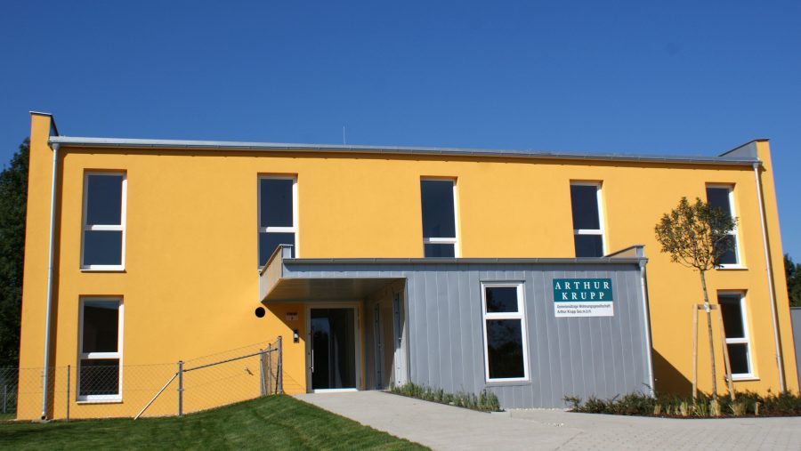 Modernes gelbes Haus mit Einfamiliencharakter und gepflegtem Eingangsbereich in ruhiger Lage. Ideal für Immobilieninteressierte.