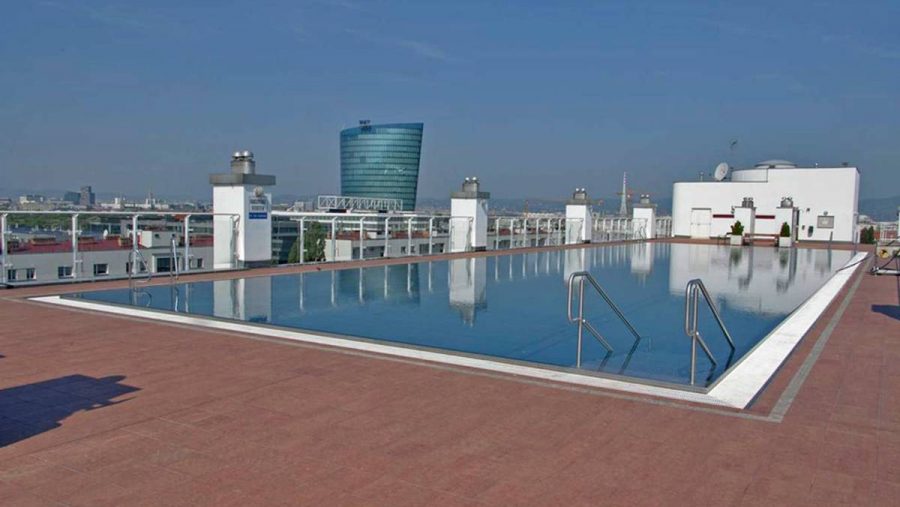 Dachterrasse mit Pool und Blick auf die Stadt, ideale Lage für eine Wohnung in Wien.
