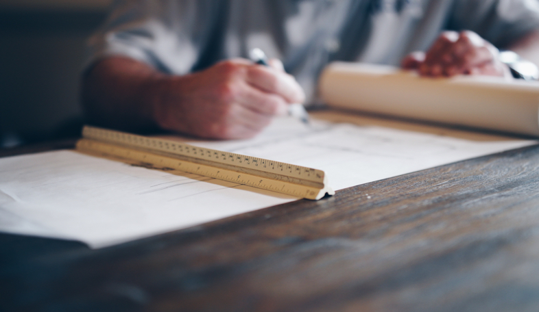 Architekt zeichnet Baupläne für modernes Hauskaufprojekt.