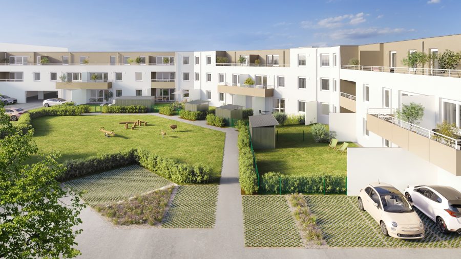 Moderne Wohnanlage mit grünem Innenhof, Parkplatz und Balkonen unter blauem Himmel.